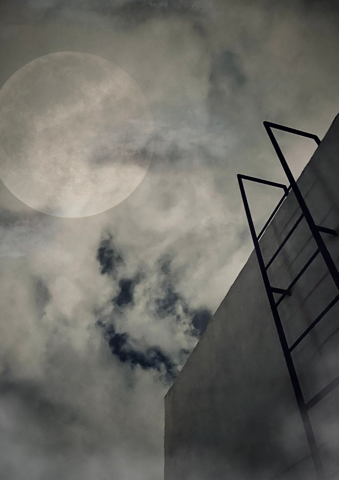 on the right side, a dark metal ladder leads up to an open roof on a grey concrete square structure. behind it, a dark cloudy sky and a large, full moon glows.