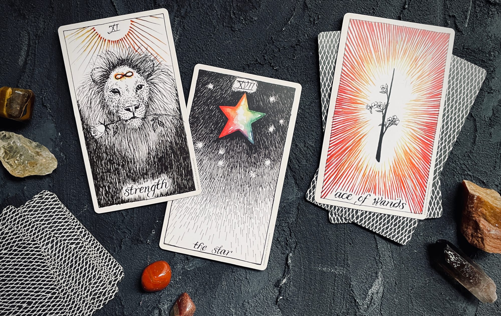 strength, the star, and the ace of wands from the wild unknown tarot