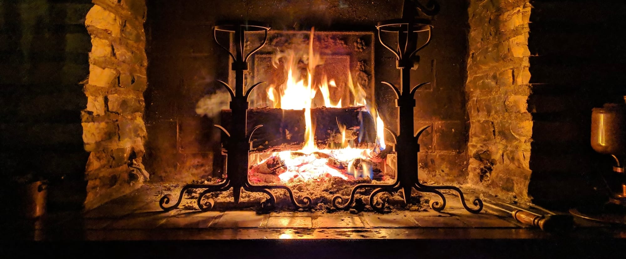 logs burning in a brick fireplace