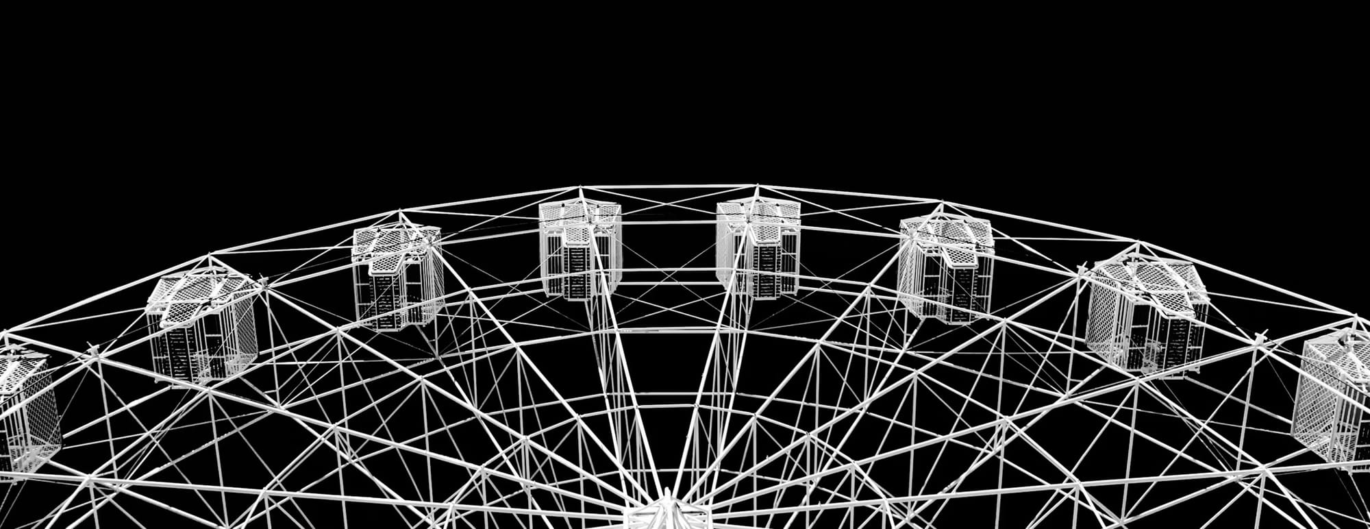 looking up view of a ferris wheel, white metal on a black background