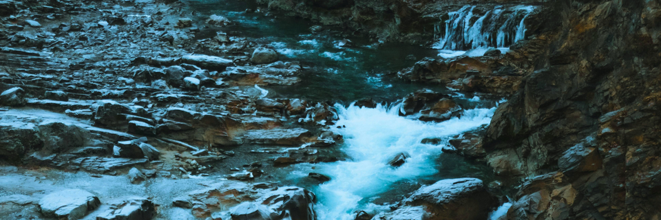photograph of a waterfall and river rapids surrounded by rocks and stone